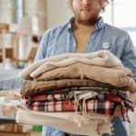 Volunteer holding folded blankets at a community donation event in South Africa