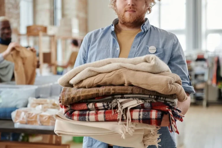 Volunteer holding folded blankets at a community donation event in South Africa